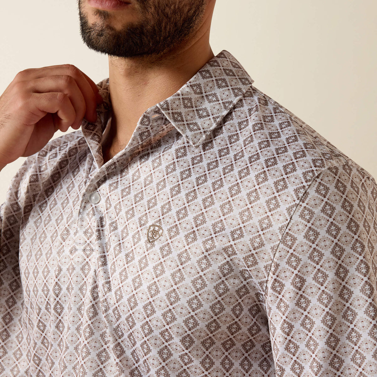 Man wearing a patterned shirt with a neutral background