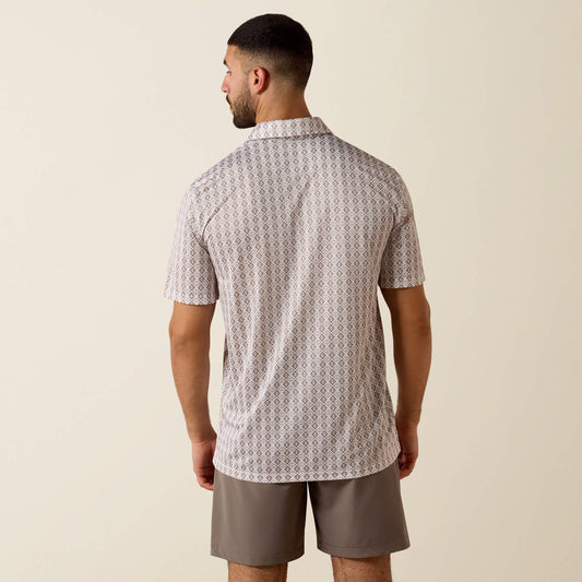Man wearing a patterned shirt and shorts on a beige background