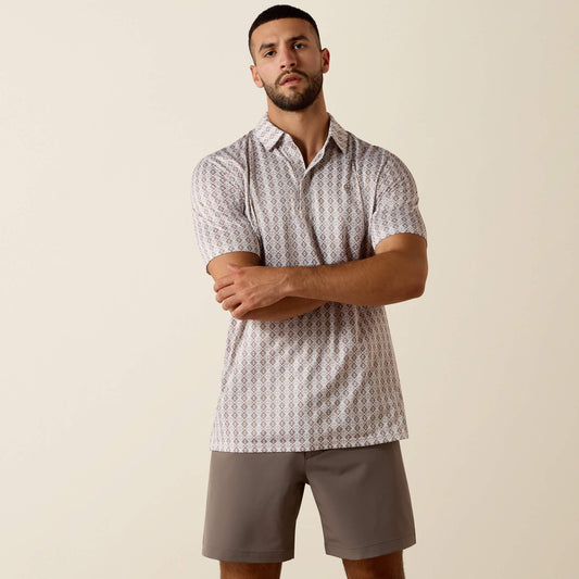 Man wearing a patterned shirt and shorts against a beige background