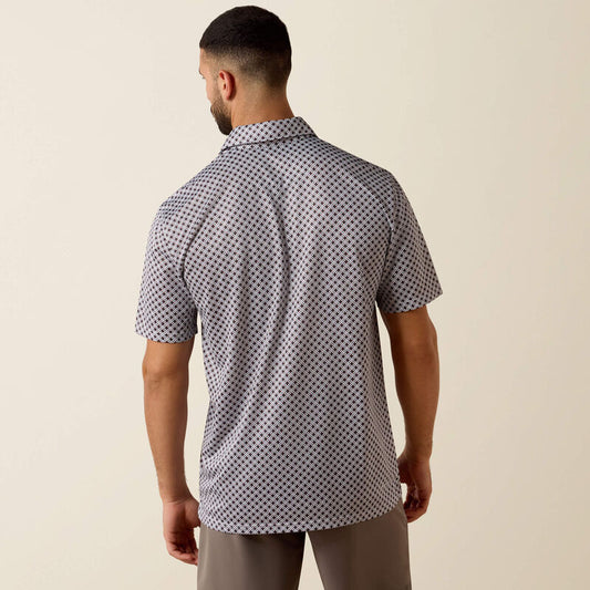 Man wearing a patterned short-sleeve shirt against a beige background