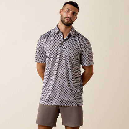 Man wearing a patterned polo shirt and shorts on a beige background
