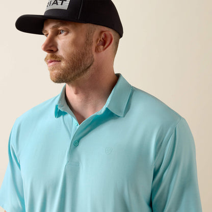 Man wearing a light blue polo shirt and black cap on a beige background