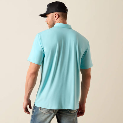 Man wearing a light blue polo shirt and black cap on a beige background