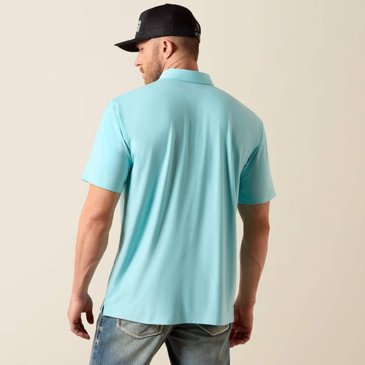 Man wearing a light blue polo shirt and black cap on a beige background