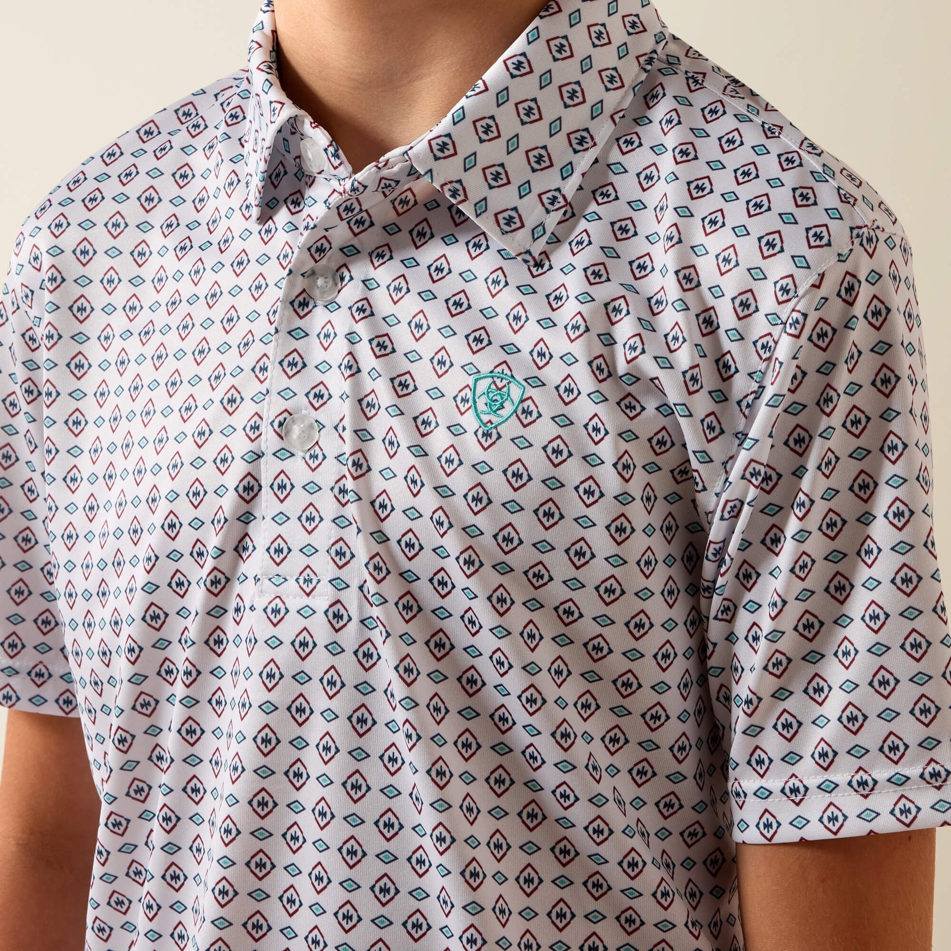 Patterned polo shirt with a brand logo on a neutral background