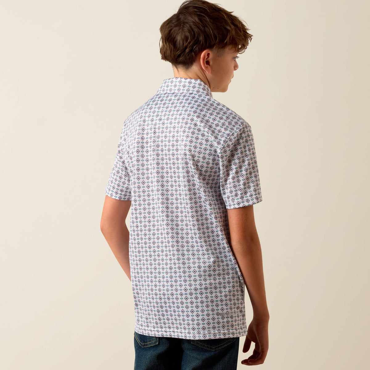 Person wearing a patterned short-sleeve shirt against a plain background