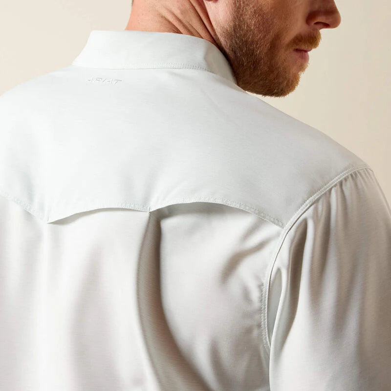 Close-up of a person wearing a light-colored shirt with a neutral background