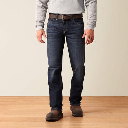 Close-up of a person wearing dark blue denim jeans, showing the back pocket with a visible Apatite brand tag and a hand pulling the waistband.