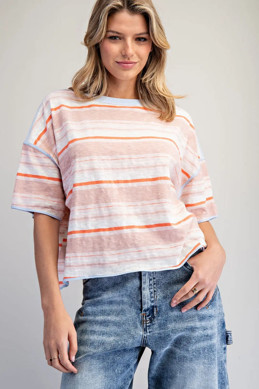 Woman wearing a striped shirt and jeans against a plain background