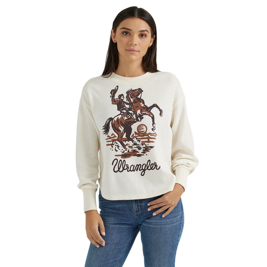 Woman wearing cream Wrangler graphic sweatshirt with cowboy and horse print, blue jeans