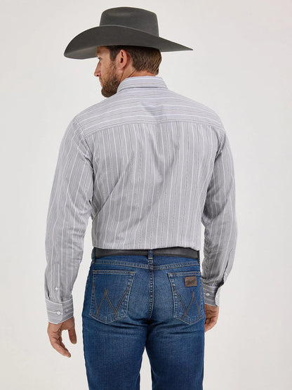 Man in a gray striped western shirt, blue jeans, and cowboy hat shown from the back