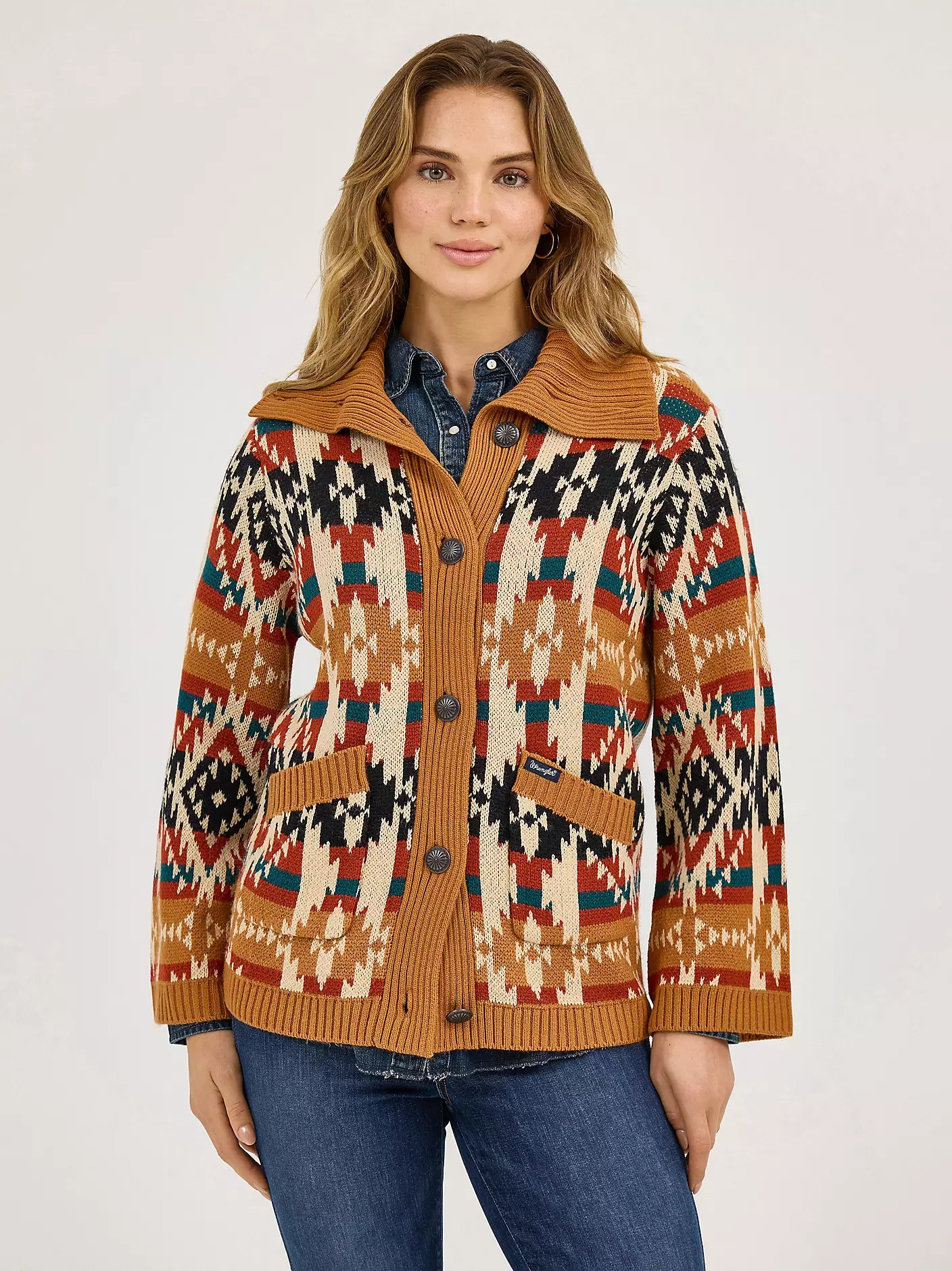 Woman wearing a button-up cardigan with southwestern geometric pattern, fall colors