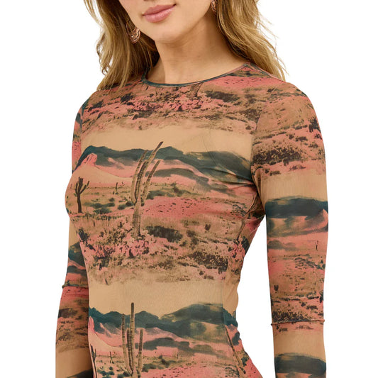 Woman wearing a long sleeve desert landscape print mesh top with cactus and mountain design