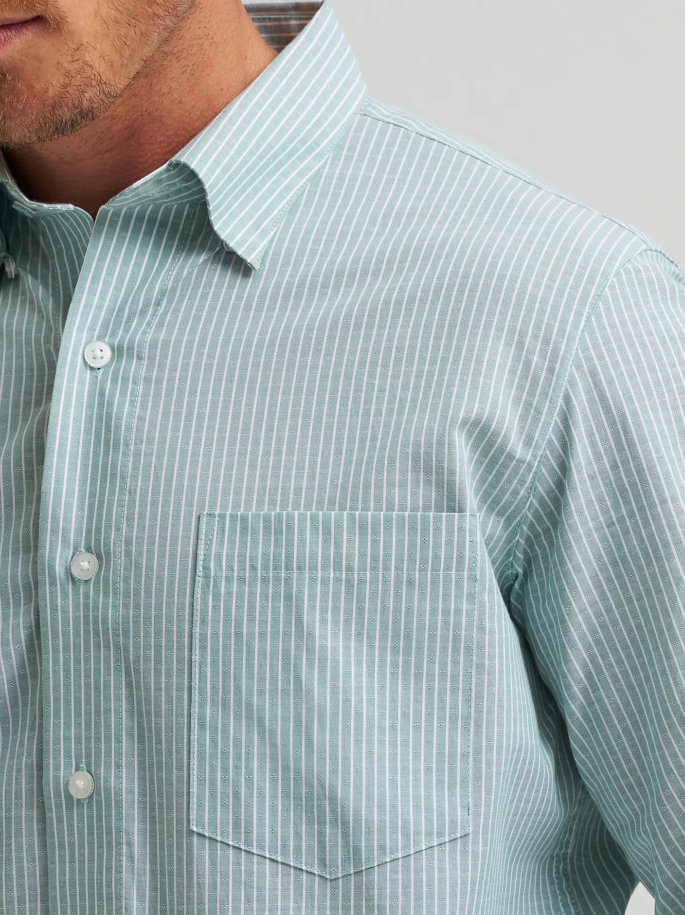 Close-up of a man wearing a light green striped shirt with a collar.