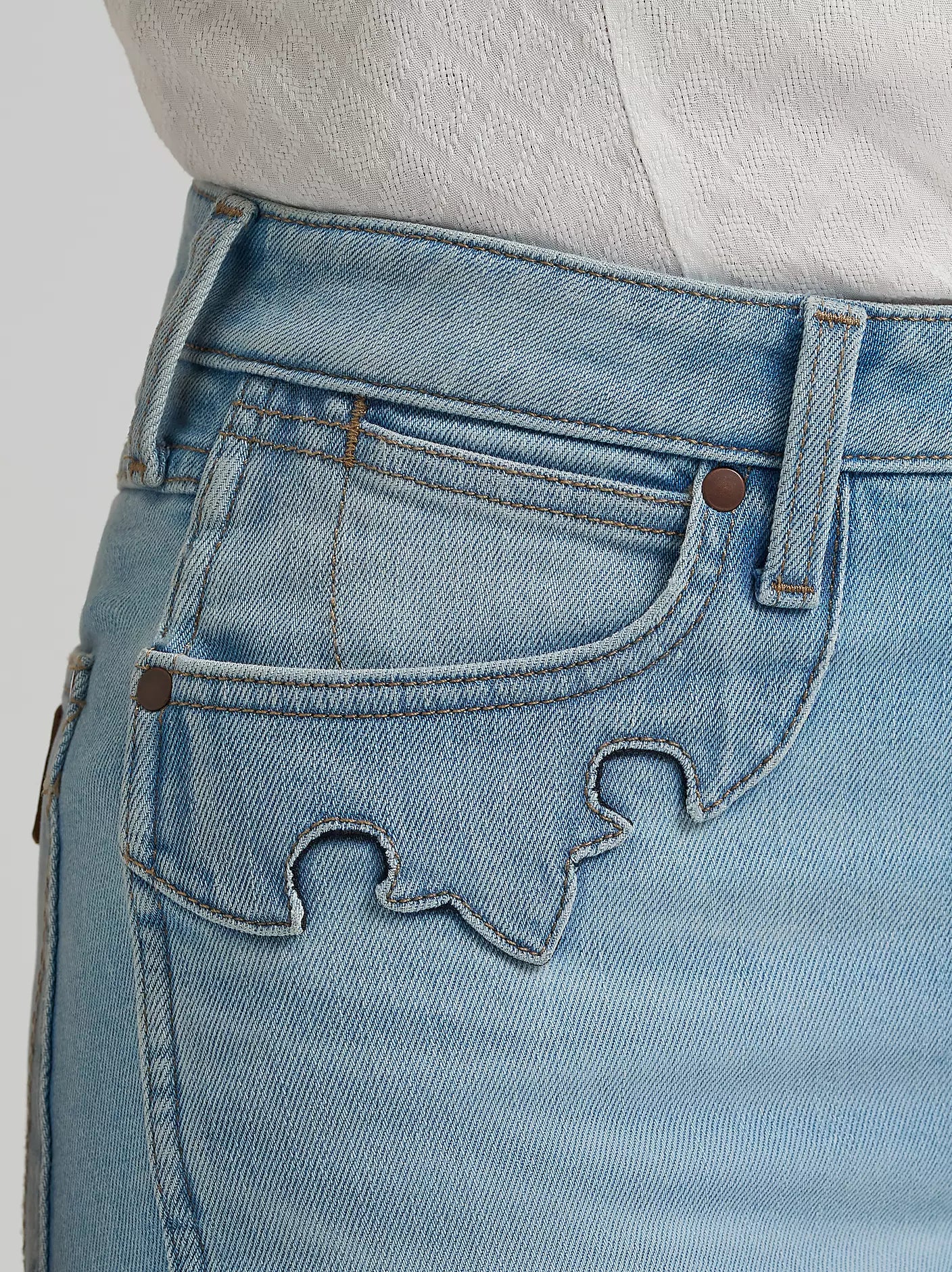 Close-up of blue jeans with a bottle opener on a gray background