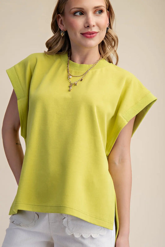 Woman wearing a yellow top with a beige background