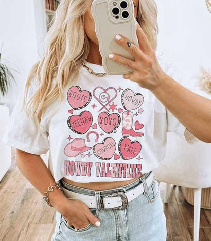 Woman wearing a white graphic tee with pink Valentine and cowboy themed designs, casual jeans outfit.