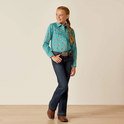 Girl wearing turquoise floral western shirt, dark blue jeans, and brown cowboy boots