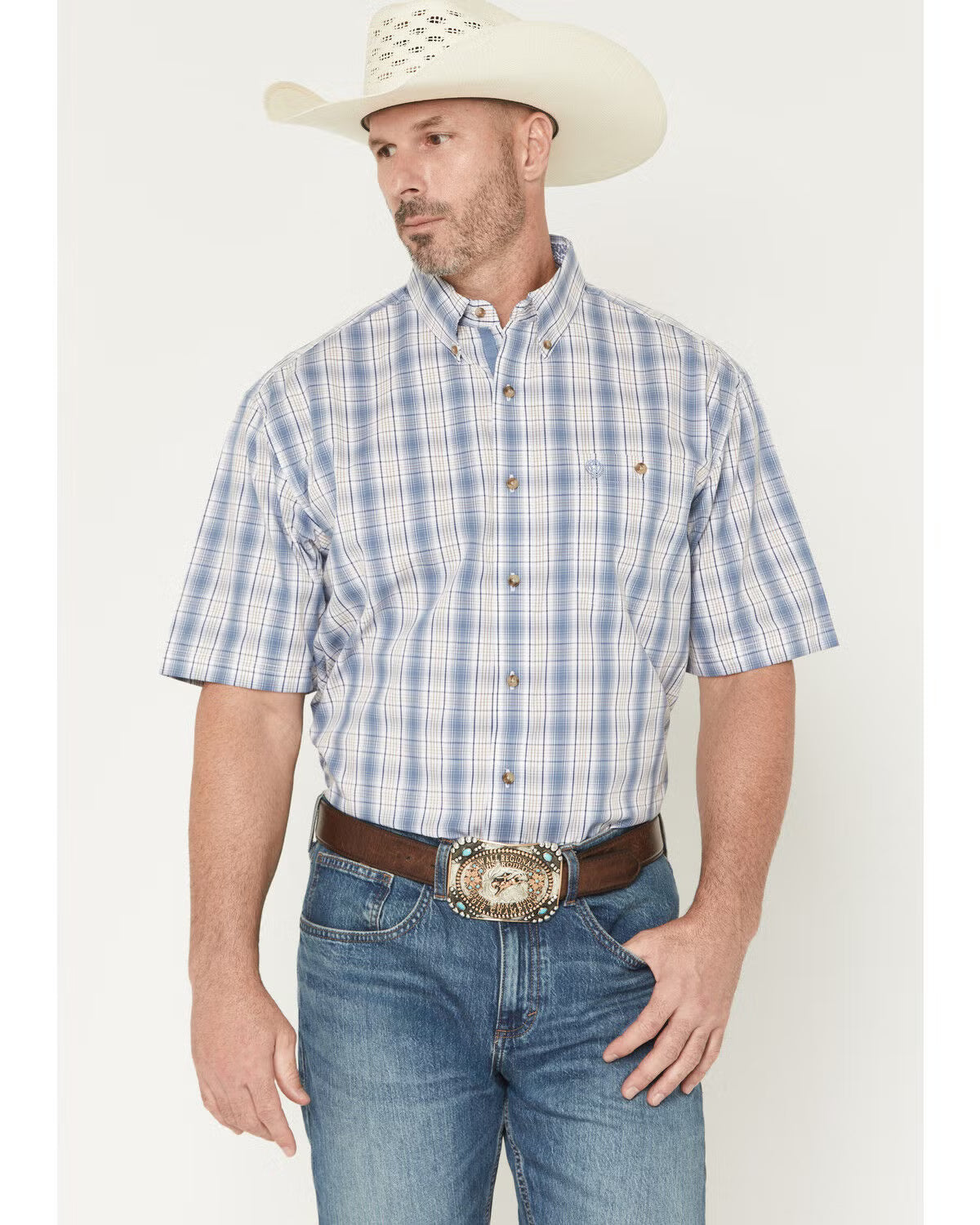 Man wearing a blue plaid shirt, jeans, and a cowboy hat on a white background