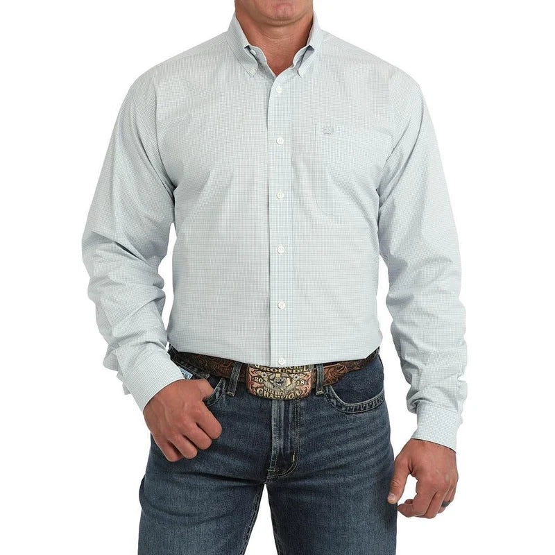 A man wearing a light blue and white micro-check long-sleeve button-down shirt with dark blue jeans and a western belt, shown from the chin down on a white background.