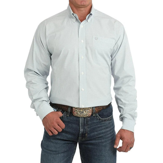 A man wearing a light blue and white micro-check long-sleeve button-down shirt with dark blue jeans and a western belt, shown from the chin down on a white background.