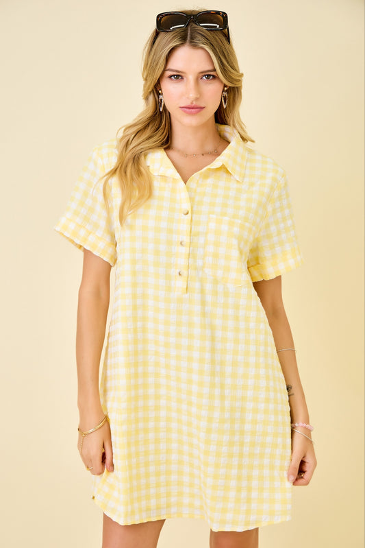 Woman wearing a yellow checkered dress against a beige background