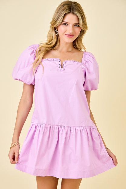 Woman wearing a pink dress against a beige background