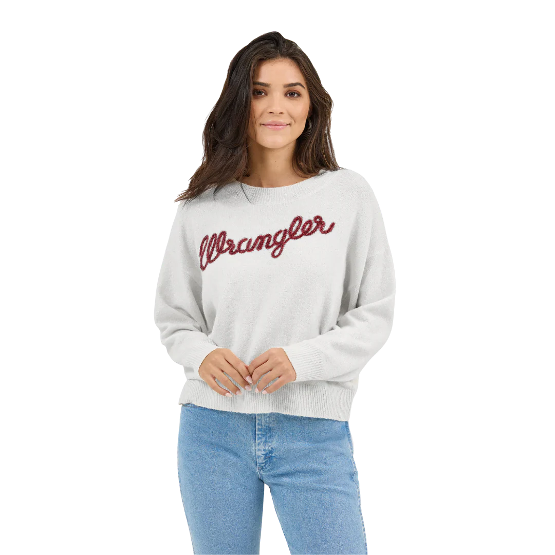 Woman wearing light grey Wrangler sweater and blue jeans on white background