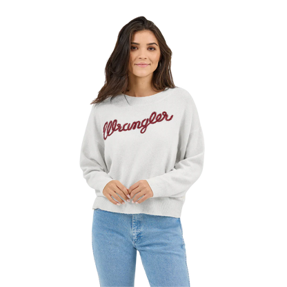 Woman wearing light grey Wrangler sweater and blue jeans on white background