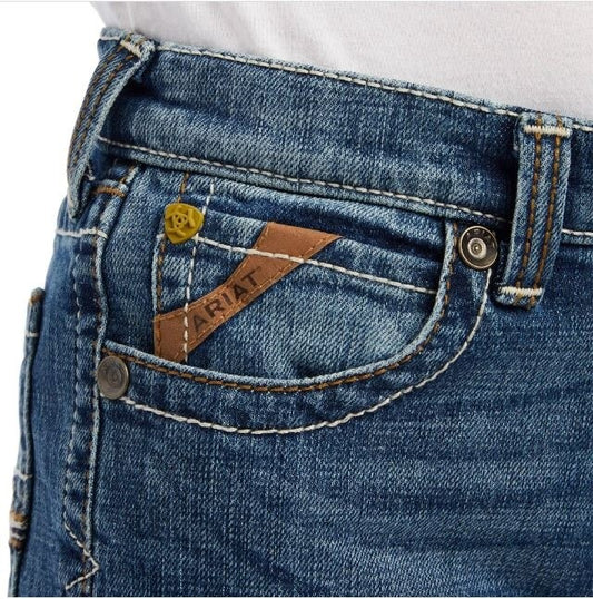 Close-up of blue jeans with a brand label on the pocket against a white background