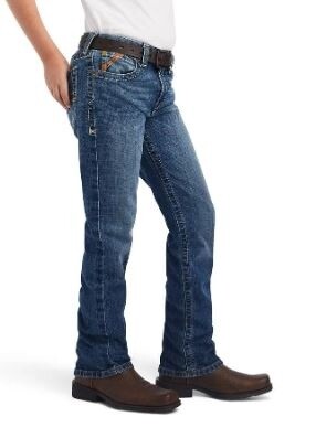 Person wearing blue jeans and brown shoes on a white background