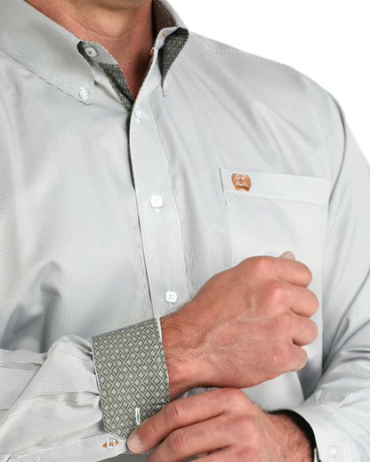 Man wearing light gray button-down shirt with patterned cuffs and chest pocket