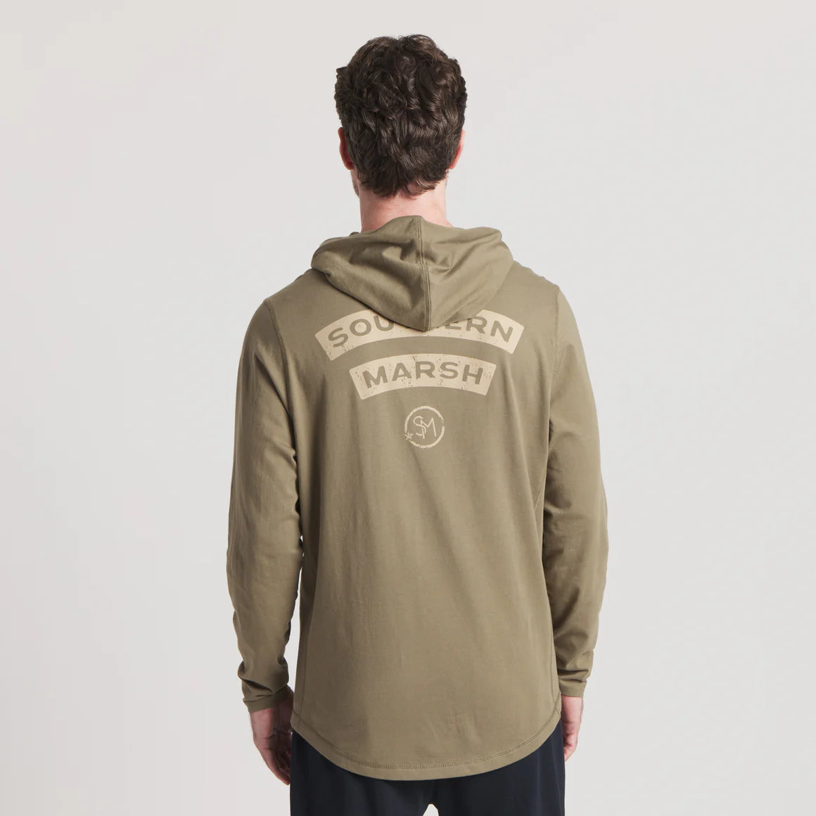 Man wearing olive green hooded long sleeve shirt with Southern Marsh logo on back