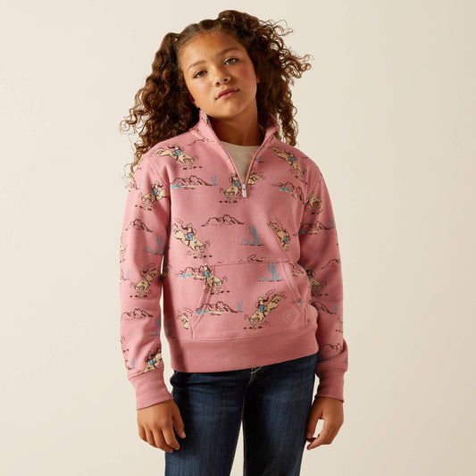 Girl wearing pink quarter-zip pullover with rodeo cowboy and horse print, casual outfit