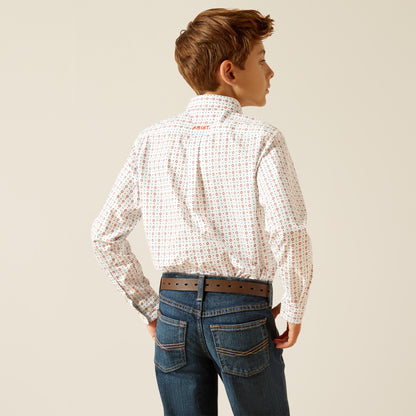 Boy wearing patterned long sleeve shirt, brown belt, and blue jeans, viewed from the back.