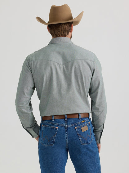 Man in cowboy hat, grey western shirt, and blue denim jeans viewed from the back