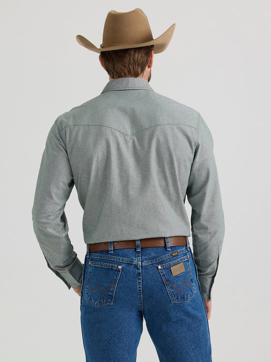 Man in cowboy hat, grey western shirt, and blue denim jeans viewed from the back