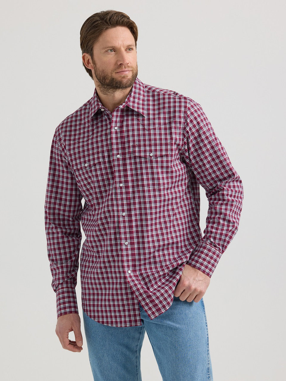 Man wearing long sleeve red plaid shirt and blue jeans, casual outfit
