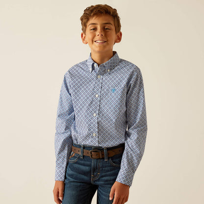Smiling boy wearing a blue patterned button-down shirt and blue jeans with brown belt