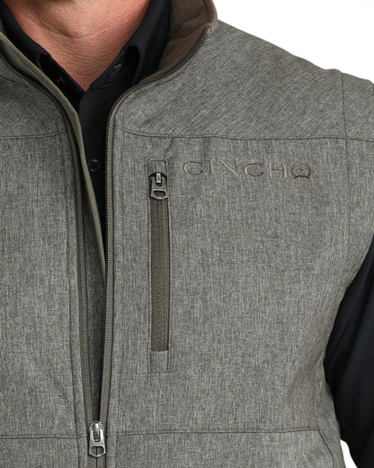 Close-up of man wearing gray zippered vest with chest pocket over black shirt