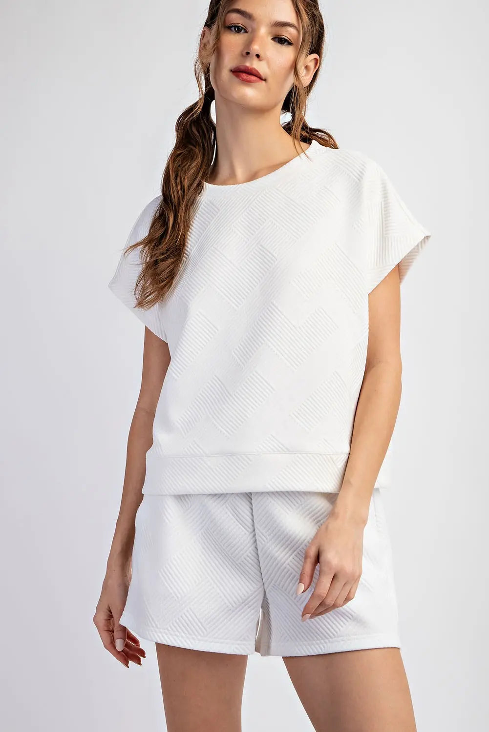 Woman wearing a white outfit with a plain background