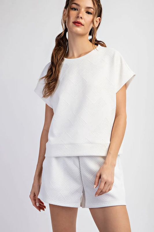 Woman wearing a white outfit with a plain background