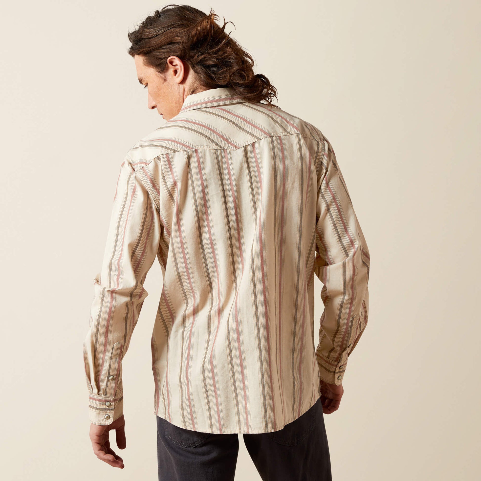 Man wearing beige and red striped long sleeve western shirt, back view