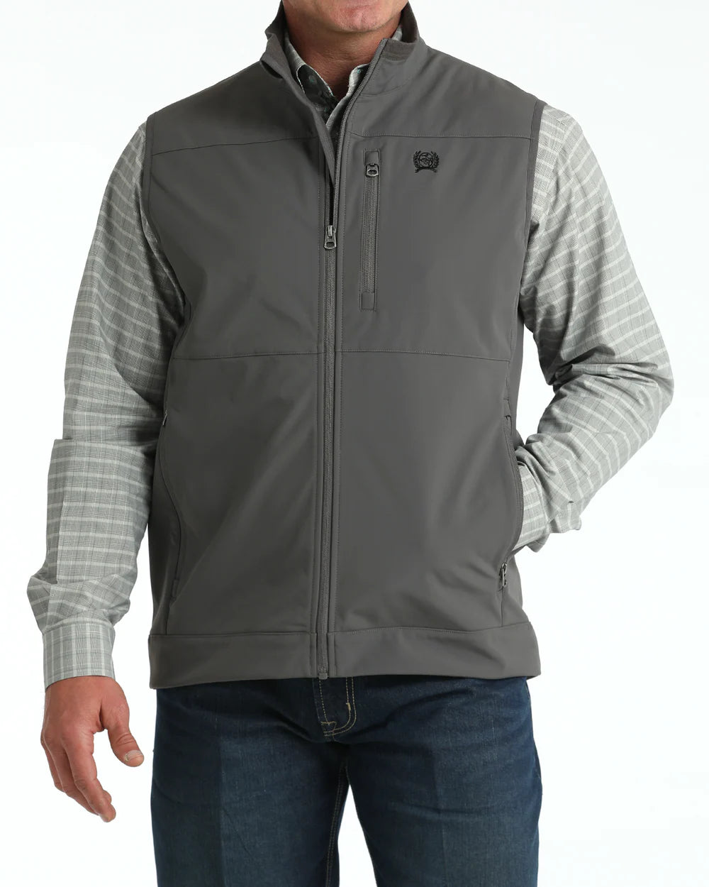 Men's gray softshell vest with zip pockets, worn over plaid shirt and jeans