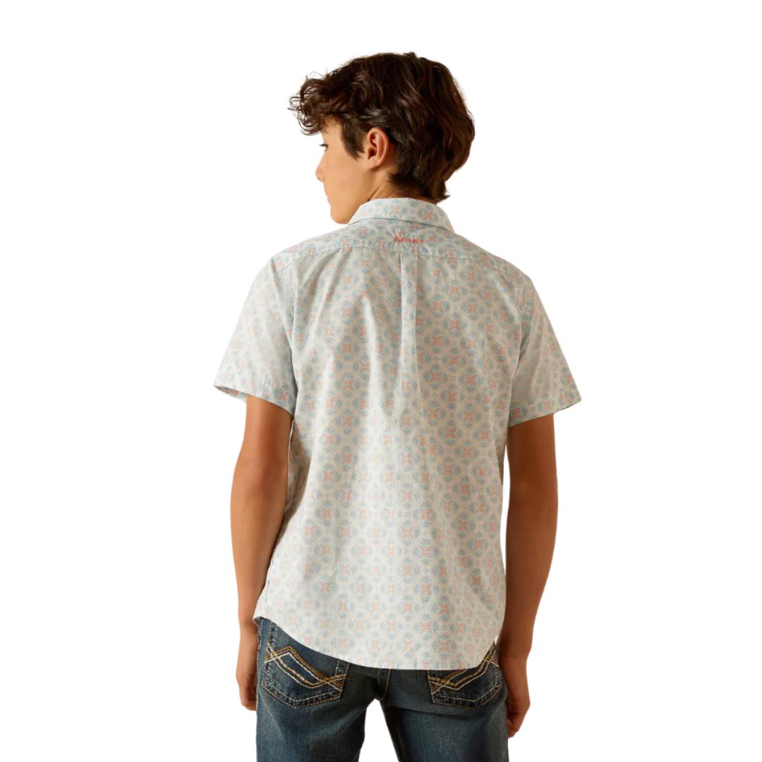 Boy wearing short sleeve patterned button-up shirt and denim jeans, rear view