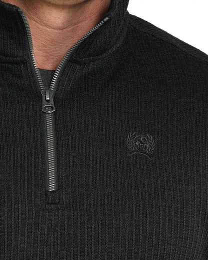Close-up of ribbed black quarter-zip sweater with subtle chest embroidery
