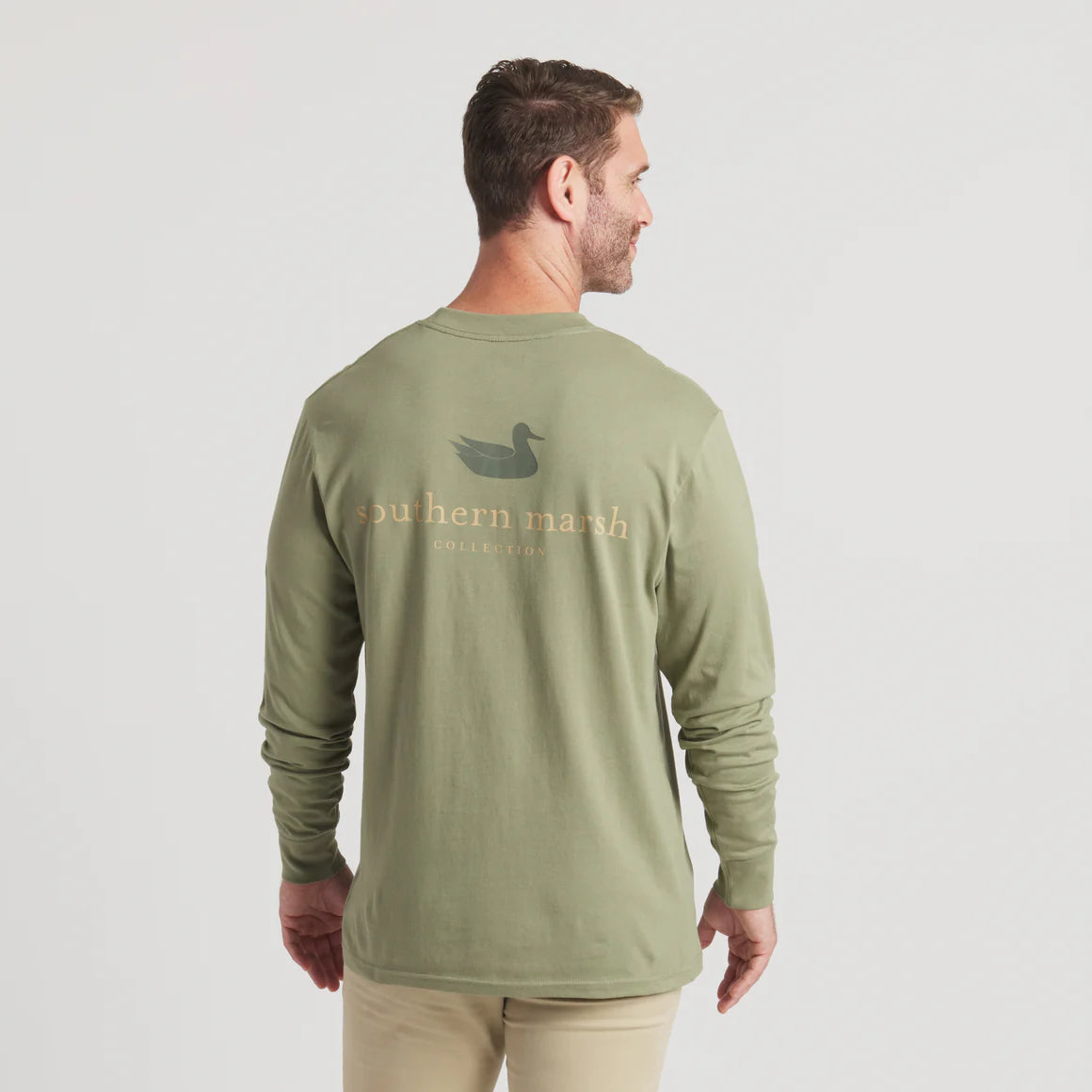 Man wearing olive green long sleeve shirt with duck logo and Southern Marsh text on back
