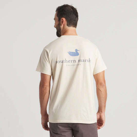 Man wearing cream t-shirt with blue duck and 'southern marsh collection' logo on back