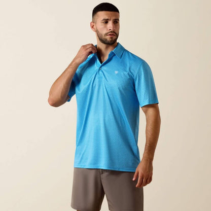 Man wearing a blue patterned polo shirt against a beige background
