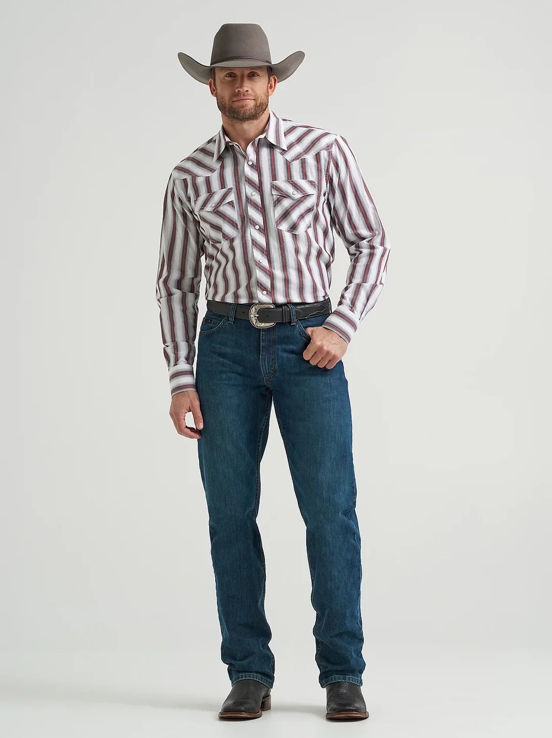 Man in striped western shirt, blue jeans, cowboy hat and boots, standing on white background